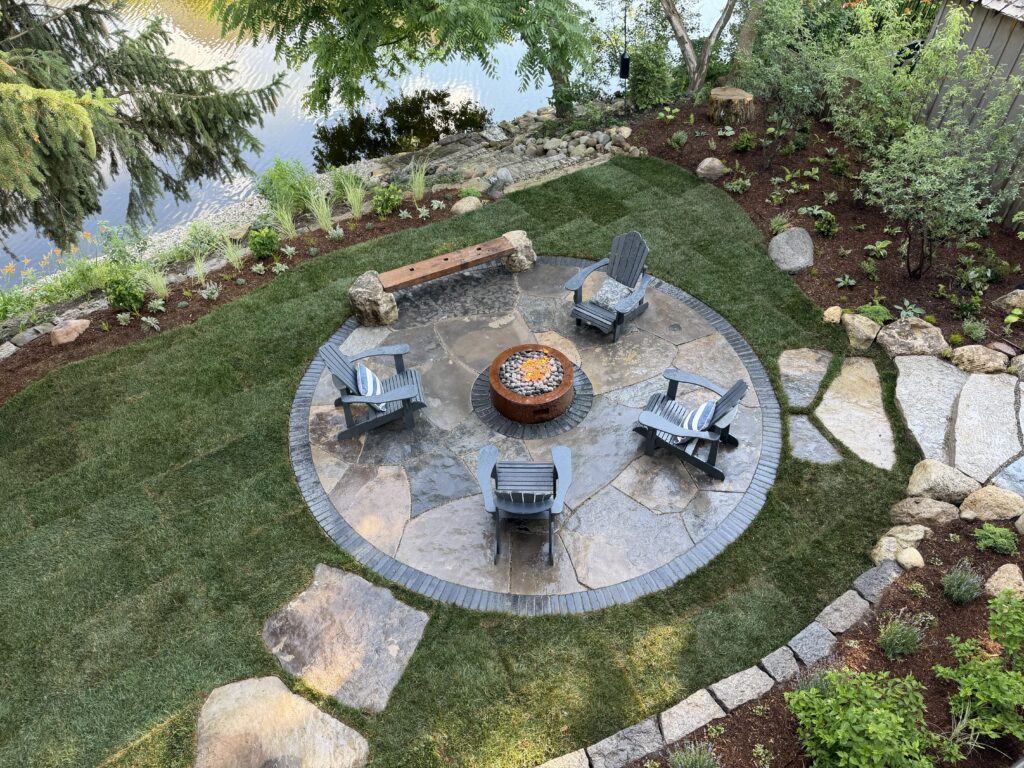 Custom riverfront flagstone patio with firepit designed by CJohnston Landscape Design in Guelph
