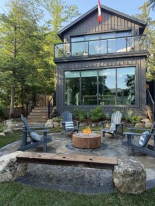 Handcrafted flagstone pad with seating area and firepit along the riverbank